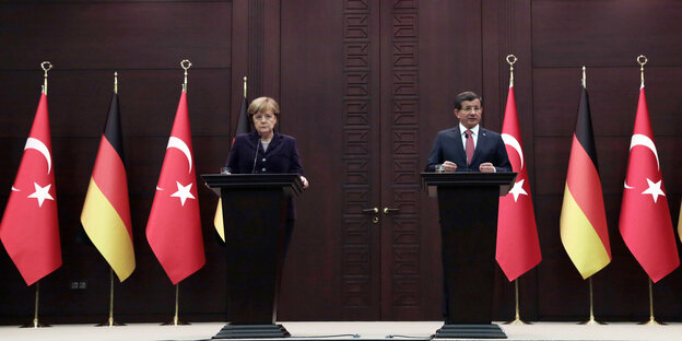 Angela Merkel, links, und Ahmet Davutoglu an Stehpulten vor deutschen und türkischen Flaggen bei der Pressekonferenz Angela Merkel, links, und Ahmet Davutoglu an Stehpulten vor deutschen und türkischen Flaggen bei der Pressekonferenz