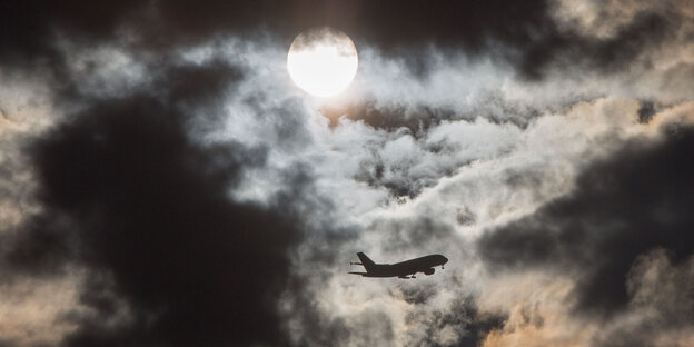 Ein Flugzeug fliegt durch den bewölkten Himmel. Ein Flugzeug fliegt durch den bewölkten Himmel.