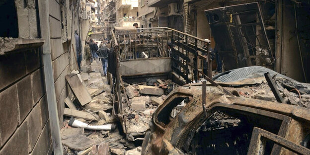 Zertrümmerte Häuser und zerbombte Autos in einer Straße Zertrümmerte Häuser und zerbombte Autos in einer Straße