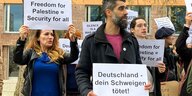 Demonstranten halten Schilder auf weißem Grund "Deutschland dein Schweigen tötet"