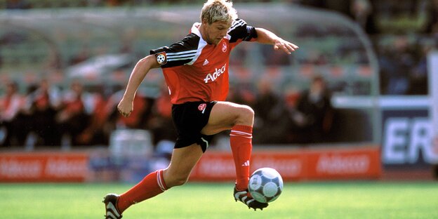 Fußballer im rot-schwarzen Trikot am Ball Fußballer im rot-schwarzen Trikot am Ball