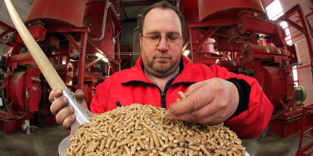 ein Mann vor einer Schippe mit Holzpallets