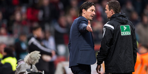 Bayer-Trainer Roger Schmidt diskutiert mit dem vierten Offiziellen