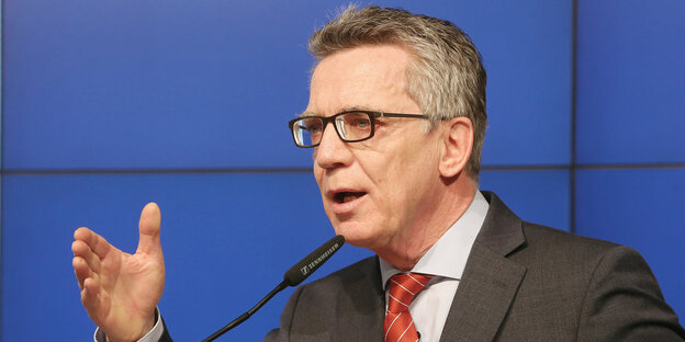 Innenminister De Maizière spricht in ein Mikrofon Innenminister De Maizière spricht in ein Mikrofon