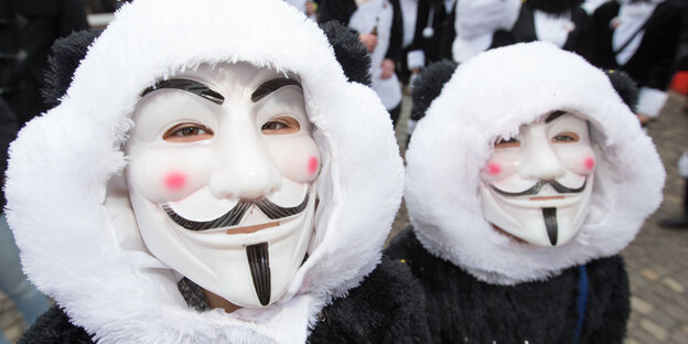 zwei Menschen mit Guy-Fawkes-Masken zwei Menschen mit Guy-Fawkes-Masken