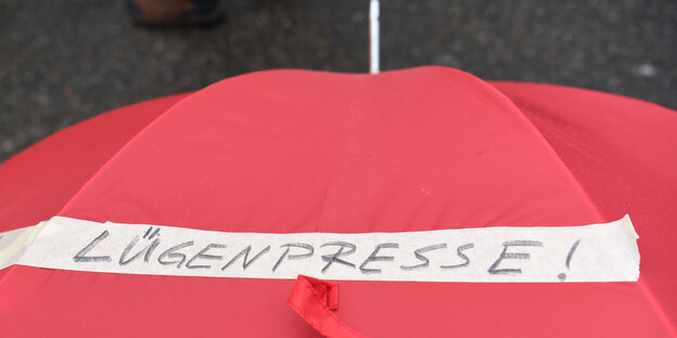 Roter Regenschirm mit der Aufschrift "Lügenpresse" Roter Regenschirm mit der Aufschrift "Lügenpresse"