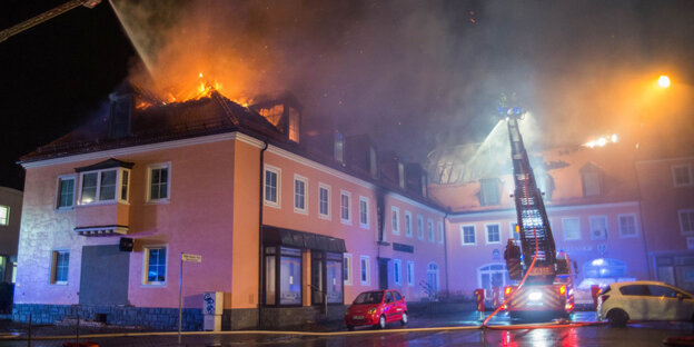 Ein Haus steht bei Nacht in Flammen. Die Feuerwehr versucht zu löschen. Ein Haus steht bei Nacht in Flammen. Die Feuerwehr versucht zu löschen.