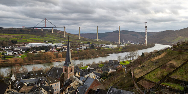 Ein Fluss fließt durch eine Landschaft. Am Horizont sieht man Brückenpfeiler. Ein Fluss fließt durch eine Landschaft. Am Horizont sieht man Brückenpfeiler.