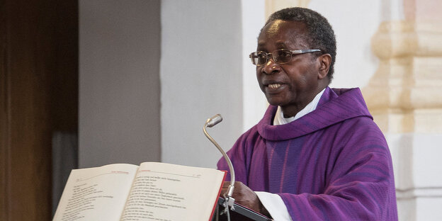 Der schwarze Pfarrer Olivier Ndjimbi-Tshiende steht am Rednerpult in einer Kirche. Der schwarze Pfarrer Olivier Ndjimbi-Tshiende steht am Rednerpult in einer Kirche.