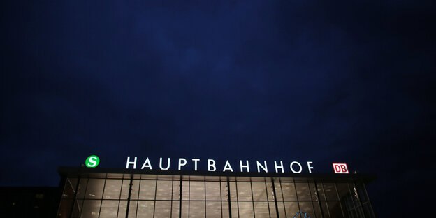 „Hauptbahnhof“ steht erleuchtet auf einem Dach. Es ist dunkel. „Hauptbahnhof“ steht erleuchtet auf einem Dach. Es ist dunkel.