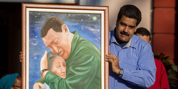 Präsident Maduro hält ein Gemälde hoch, auf dem der ehemalige Präsident Chavez seine Mutter umarmt Präsident Maduro hält ein Gemälde hoch, auf dem der ehemalige Präsident Chavez seine Mutter umarmt