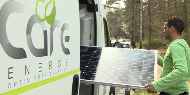 Care-Energy-Mitarbeiter mit Solar-Panel Care-Energy-Mitarbeiter mit Solar-Panel