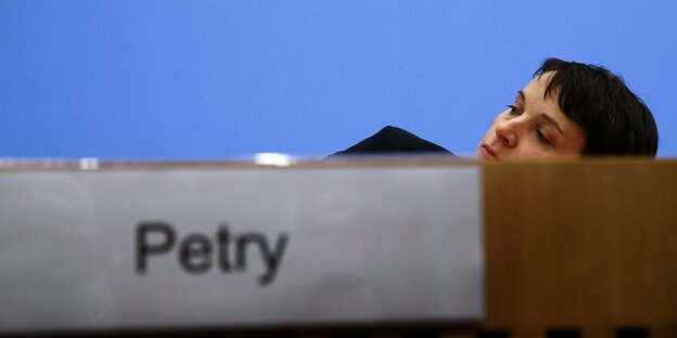 Frauke Petry duckt sich hinter dem Pult der Bundespressekonferenz, so dass nur noch ihr Kopf zu sehen ist. Frauke Petry duckt sich hinter dem Pult der Bundespressekonferenz, so dass nur noch ihr Kopf zu sehen ist.