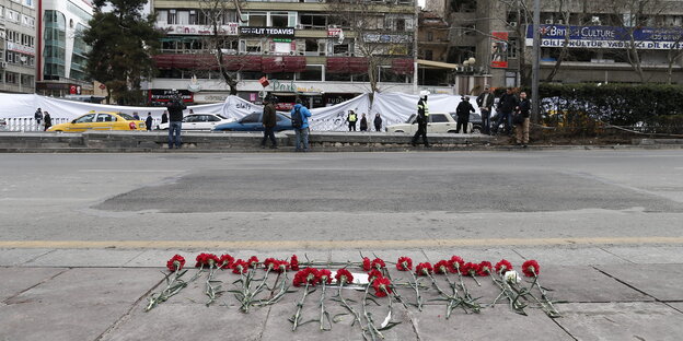 Eine Straßenansicht. Rosen liegen auf dem Bürgersteig Eine Straßenansicht. Rosen liegen auf dem Bürgersteig