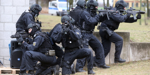 schwer bewaffnete Polizisten mit Maschinenpistolen im Anschlag