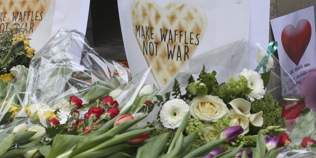 Blumen und ein Schild „Waffeln statt Krieg" Blumen und ein Schild „Waffeln statt Krieg"