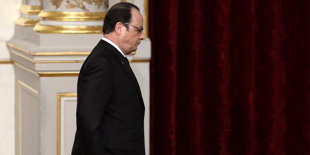 Ein Mann im schwarzen Anzug, Francois Hollande, ist von der Seite zu sehen Ein Mann im schwarzen Anzug, Francois Hollande, ist von der Seite zu sehen