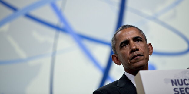 Obama schaut ernst vom Podium Obama schaut ernst vom Podium