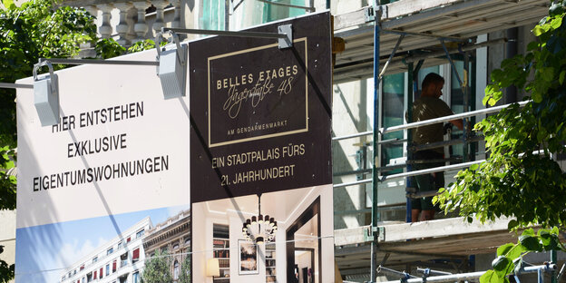 An einem Baugerüst hängt Werbung für Luxuseigentumswohnungen An einem Baugerüst hängt Werbung für Luxuseigentumswohnungen