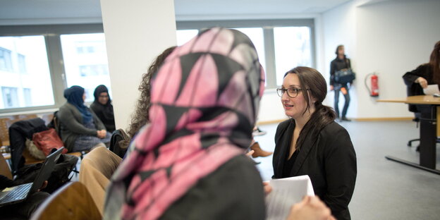 Die Rechtsanwältin Maryam Haschemi Yekani hockt am 14.04.2016 im Berliner Arbeitsgericht vor einer Frau mit Kopftuch Die Rechtsanwältin Maryam Haschemi Yekani hockt am 14.04.2016 im Berliner Arbeitsgericht vor einer Frau mit Kopftuch