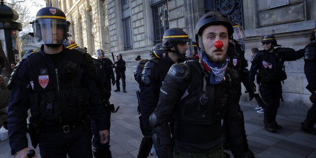 Links ein Polizist mit Schutzhelm, rechts ein Demonstrant mit roter Nase Links ein Polizist mit Schutzhelm, rechts ein Demonstrant mit roter Nase
