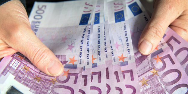 Zwei Hände, die 500-Euro-Scheine halten Zwei Hände, die 500-Euro-Scheine halten