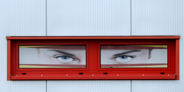 Eine mit Augenplakaten dekorierte Fensterfront an einem Gebäude Eine mit Augenplakaten dekorierte Fensterfront an einem Gebäude