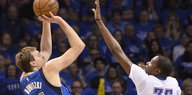 Dirk Nowitzki wirft einen Basketball, ein Gegenspieler der Oklahoma City Thunder versucht, den Wurf zu blocken.