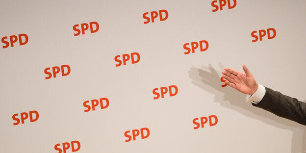 ein Arm vor einer mit SPD-Logos bedruckten Wand ein Arm vor einer mit SPD-Logos bedruckten Wand