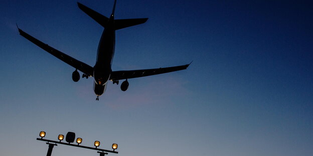 Ein Flugzeug vor einem dunkelblauen Abendhimmel Ein Flugzeug vor einem dunkelblauen Abendhimmel