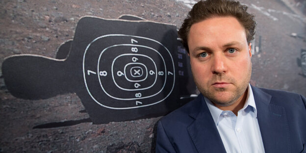 Ein Mann lehnt sich gegen eine Wand mit aufgemalter Zielscheibe Ein Mann lehnt sich gegen eine Wand mit aufgemalter Zielscheibe