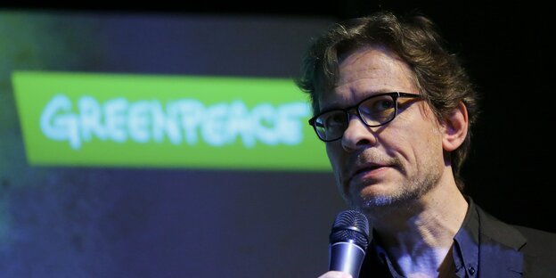 Stefan Krug spricht vor einem Greenpeace-Logo Stefan Krug spricht vor einem Greenpeace-Logo