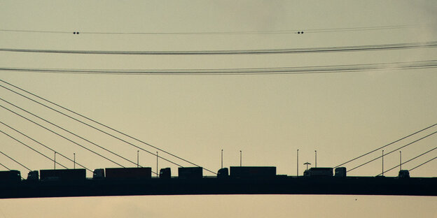 LKWs fahren im Sonnenuntergang auf der Köhlbrandbrücke in Hamburg LKWs fahren im Sonnenuntergang auf der Köhlbrandbrücke in Hamburg