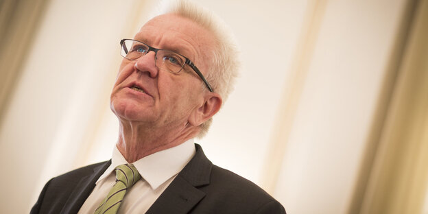 Ein Mann blickt aus dem Bild. Es ist Winfried Kretschmann Ein Mann blickt aus dem Bild. Es ist Winfried Kretschmann