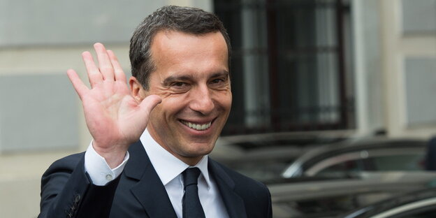 ein Mann grüßt grinsend mit der Hand ein Mann grüßt grinsend mit der Hand