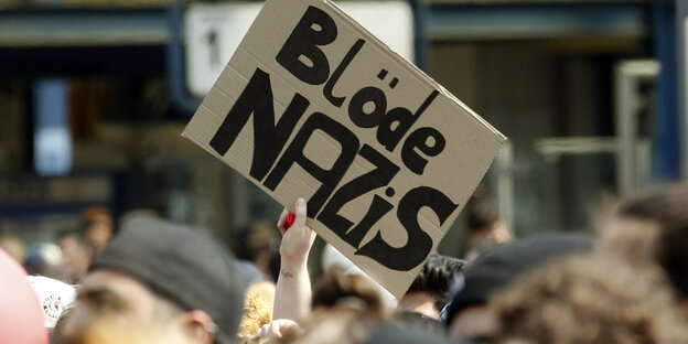 In einer Demo wird ein Plakat mit der Aufschrift „Blöde Nazis“ hochgehalten In einer Demo wird ein Plakat mit der Aufschrift „Blöde Nazis“ hochgehalten