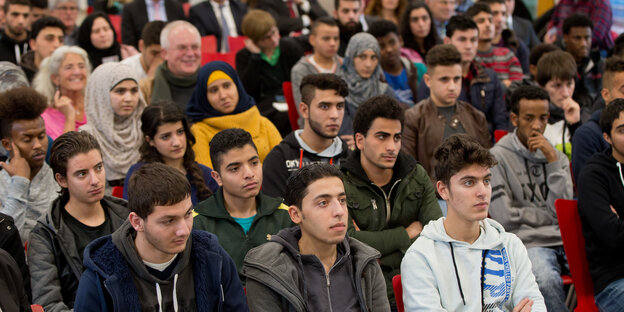 Flüchtlinge hören in einer Berufsschule in Ansbach, Bayern, beim Startschusss für das Projekt "Rechtsbildungsunterricht für Flüchtlinge" dem bayerischen Justizminister zu