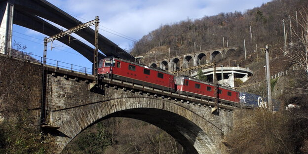 ein roter Zug überquert eine alte Brücke ein roter Zug überquert eine alte Brücke