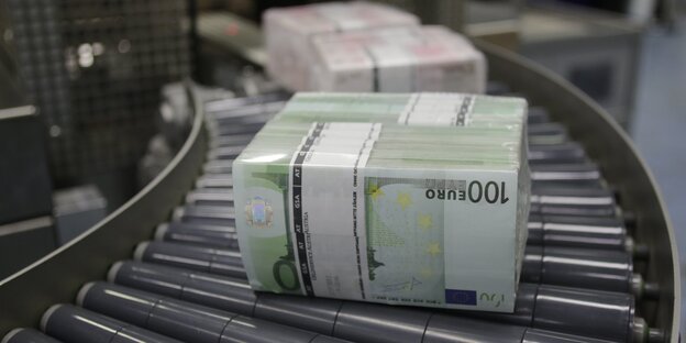 Bündel von 100-Euro-Scheinen auf einem Fließband Bündel von 100-Euro-Scheinen auf einem Fließband