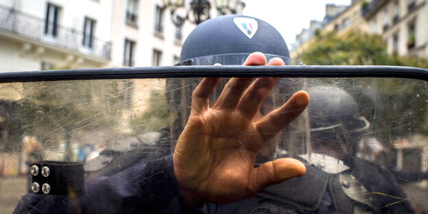 Ein Polizist hält seine Hand und sein Schild direkt in die Kamera Ein Polizist hält seine Hand und sein Schild direkt in die Kamera