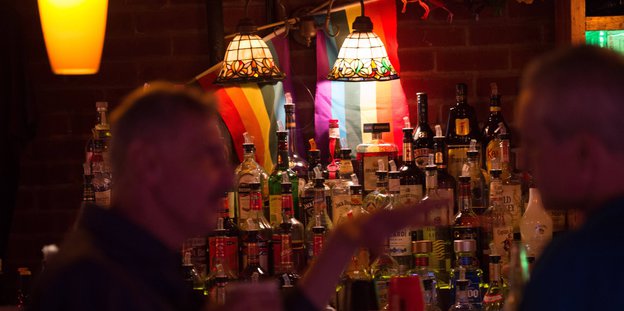 Zwei Männer unterhalten sich hinter in einer New Yorker Bar Zwei Männer unterhalten sich hinter in einer New Yorker Bar
