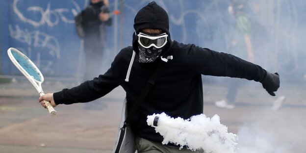 Demonstrant schlägt eine Gaskartusche der Polizei mit einem Tennisschläger zurück Demonstrant schlägt eine Gaskartusche der Polizei mit einem Tennisschläger zurück