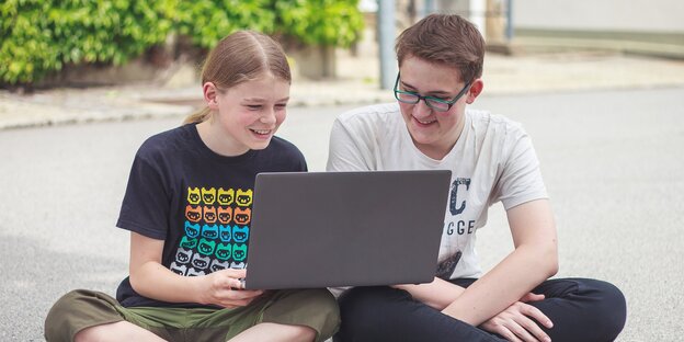 Zwei Jugendliche schauen auf ein Laptop Zwei Jugendliche schauen auf ein Laptop