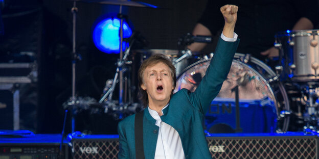 Paul McCartney auf der Bühne. Er reckt die Faust. Paul McCartney auf der Bühne. Er reckt die Faust.