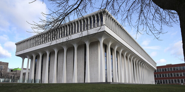 Eine weiße Halle mit Säulenarchitektur auf einer grünen Wiese, dahinter blauer Himmel mit weißen Wolken Eine weiße Halle mit Säulenarchitektur auf einer grünen Wiese, dahinter blauer Himmel mit weißen Wolken