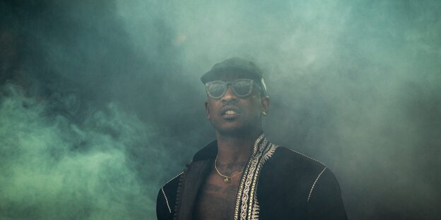 Skepta umhüllt von grünlichen Nebelschwaden Skepta umhüllt von grünlichen Nebelschwaden