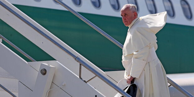 Ein älterer Herr auf einer Gangway zu einem Flugzeug. Es ist der Papst Ein älterer Herr auf einer Gangway zu einem Flugzeug. Es ist der Papst