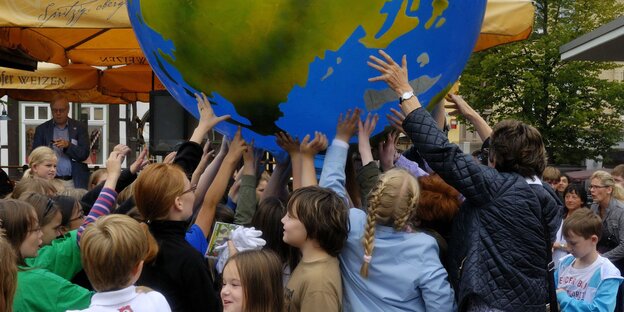 Menschen halten einen Ballon Menschen halten einen Ballon