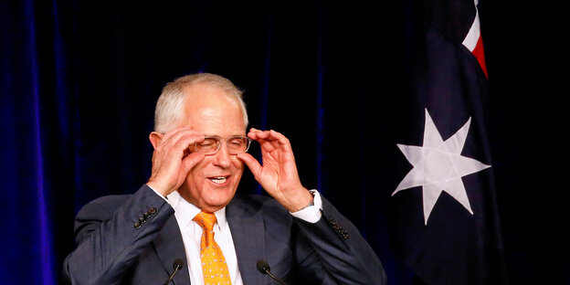 Malcolm Turnbull, ein älterer Mann mit Glatze rückt mit beiden Händen seine Brille zurecht Malcolm Turnbull, ein älterer Mann mit Glatze rückt mit beiden Händen seine Brille zurecht