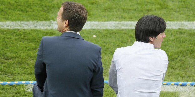 Die Rückseite von Oliver Bierhoff und Jogi Löw, die am Spielfeldrand stehen Die Rückseite von Oliver Bierhoff und Jogi Löw, die am Spielfeldrand stehen